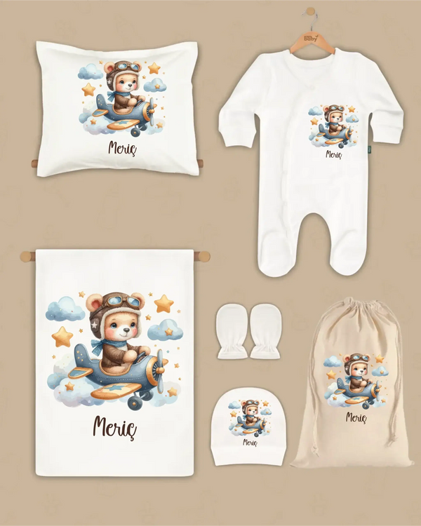 Gepersonaliseerde newborn geschenken set met vliegtuigbeer en naam, inclusief deken, kussen, boxpakje en hoed.