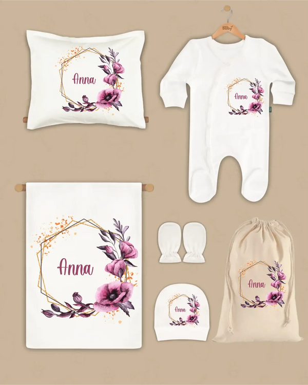Gepersonaliseerde 6-delige newborn cadeauset met paarse bloemen, inclusief kussen, boxpakje en hoed, naam Anna.