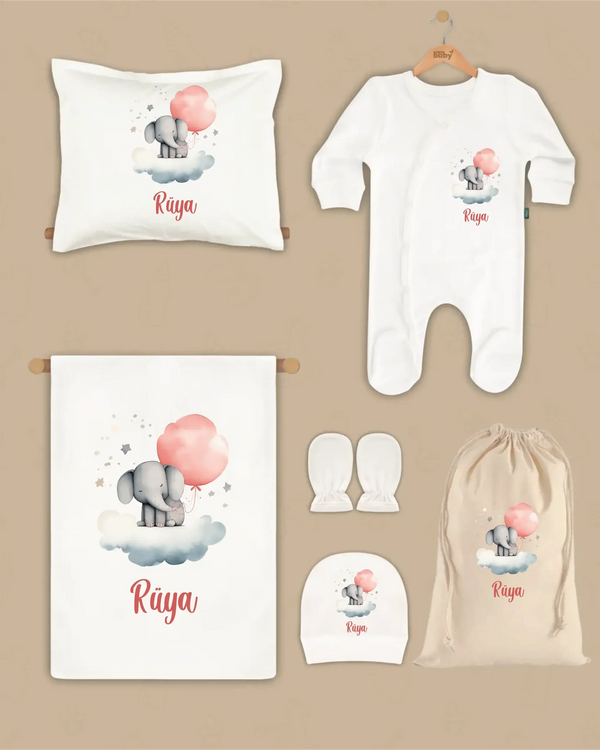 Gepersonaliseerde newborn kleding set met olifant en naam, inclusief deken, kussen, boxpakje, hoed en handschoenen.