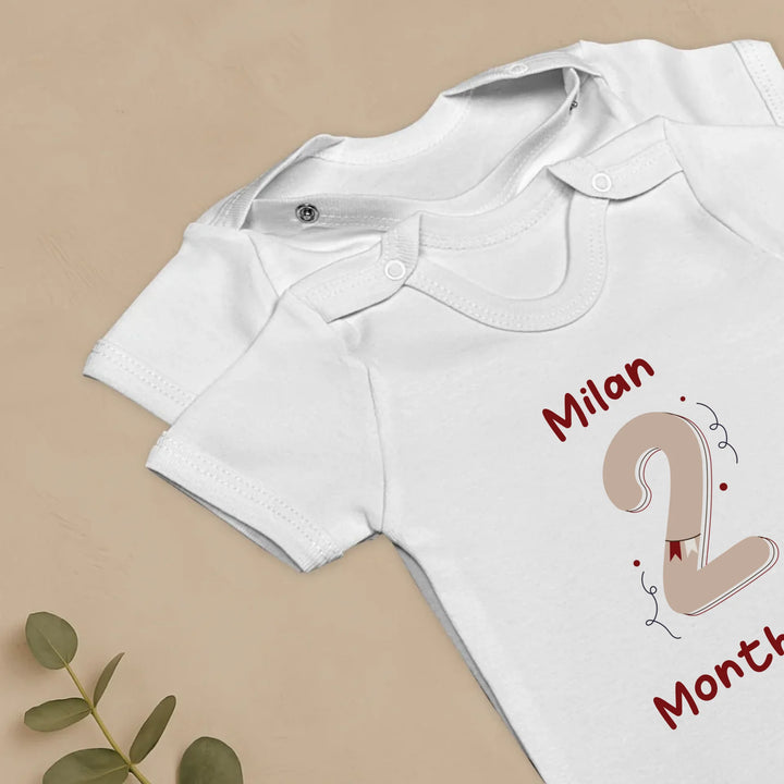 Vintage milestone baby romper set with name 'Milan' and '2 Months' print, stylish design for celebrating baby milestones.