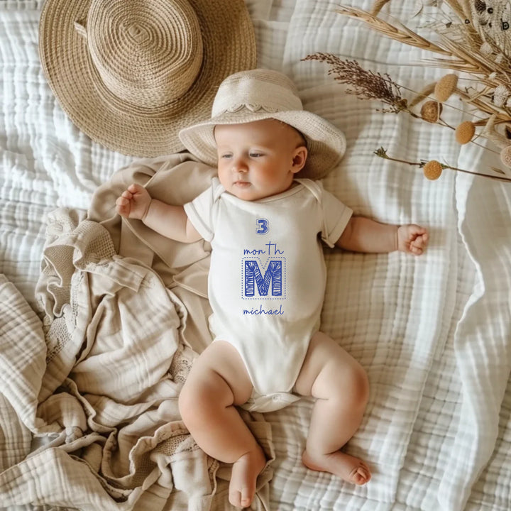 3 month milestone baby romper personalized with name Michael on cozy blanket with hat