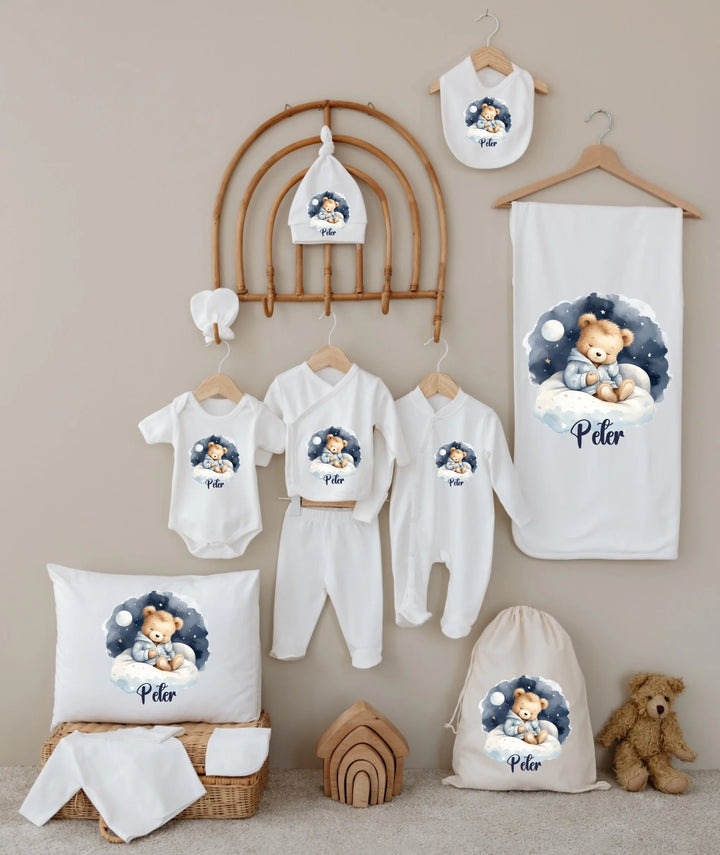 Gepersonaliseerde Teddybeer babykleding set met naam op zachte blauwe wolken achtergrond voor jongens.