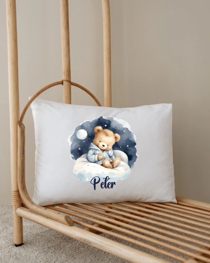 Gepersonaliseerde kussen met teddybeer ontwerp en naam 'Peter' in zachte blauwe wolkenstijl.