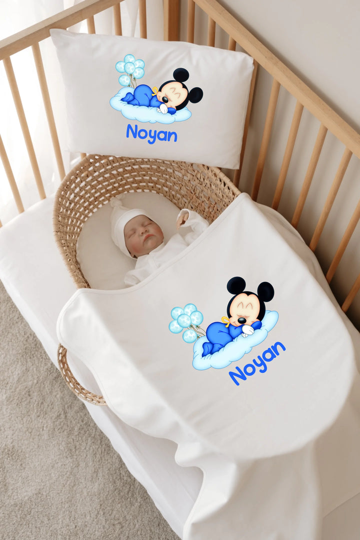 Gepersonaliseerde babybedset met Noyan en schattige muis op kussen en deken in een kinderbedje.