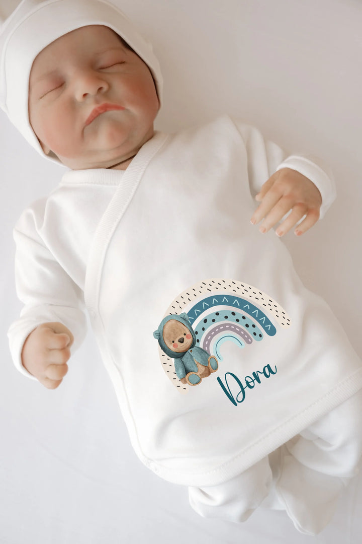 Gepersonaliseerde baby romper met regenboogprint en naam 'Dora' voor een schattige uitstraling.