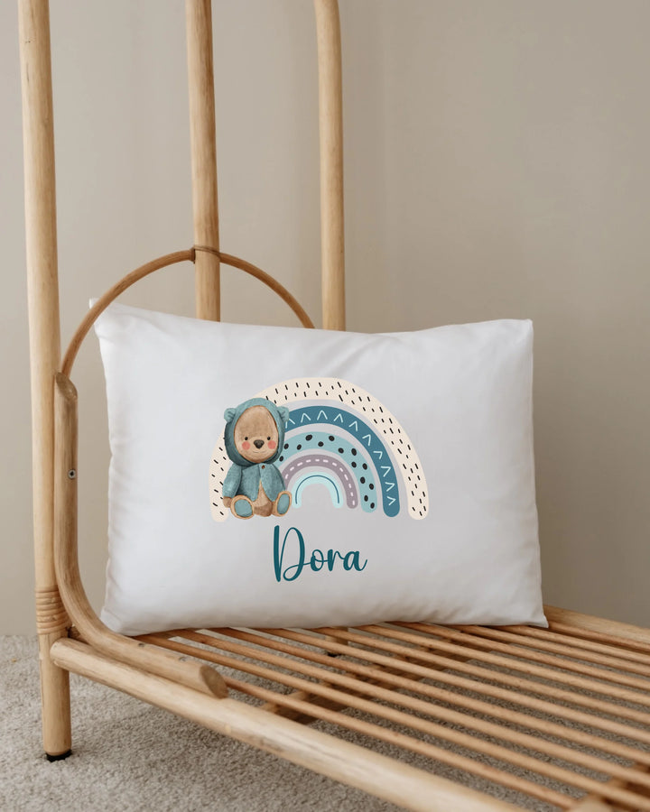 Gepersonaliseerd kussen met regenboogprint en naam Dora, perfect voor babykamerdecoratie.