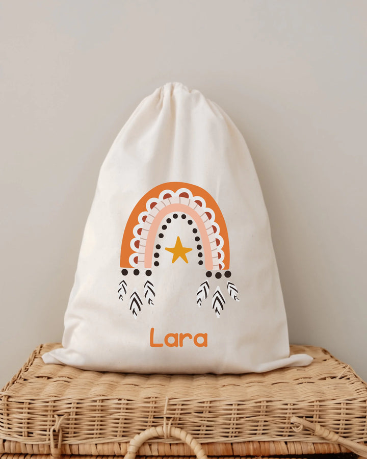Gepersonaliseerde tas met oranje regenboog en ster, bedrukt met de naam Lara, perfect voor babyspullen.