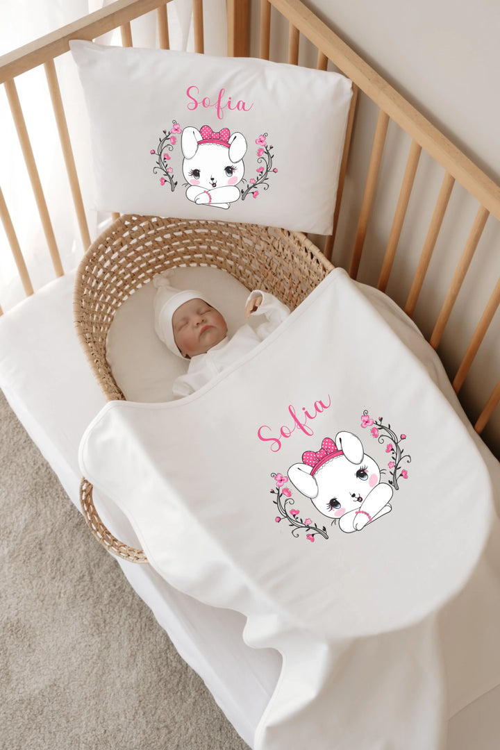 Slaapkamer met gepersonaliseerde dekens en kussens voor baby Sofia, schattig konijntje met roze strik en bloemen.