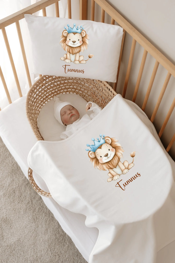 Gepersonaliseerde babybedset met schattige leeuwenkroon en naam op dekbed en kussen in een wieg.