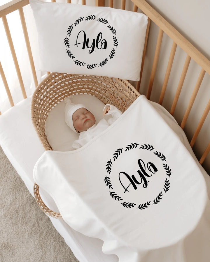 Gepersonaliseerde newborn set met naam Ayla, minimalistische cirkelprint in een wieg met baby.