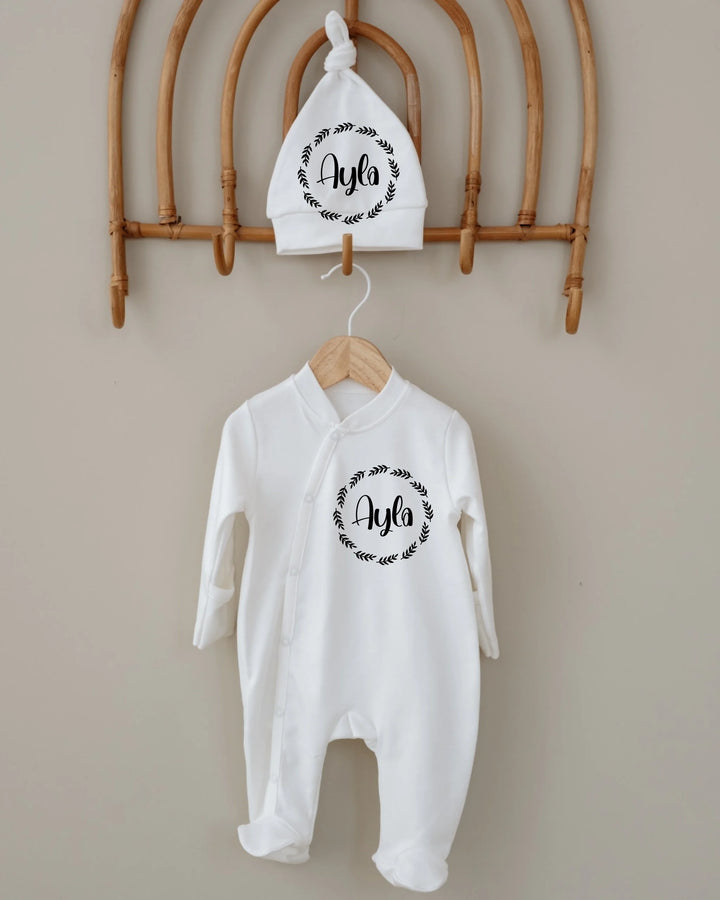 Witte newborn outfit met naam 'Ayla' en bijpassend mutsje in minimalistische stijl.