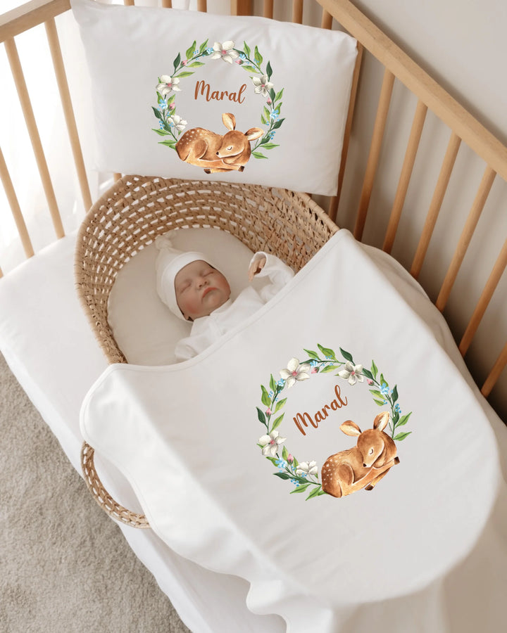 Gepersonaliseerde newborn set met slapend hertje in bloemenkrans voor baby's, met naam op kussens en dekens.