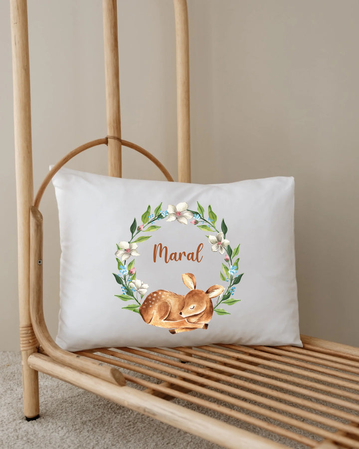 Gepersonaliseerd kussen met slapend hertje en bloemenkrans, perfect voor babykamer decoratie.