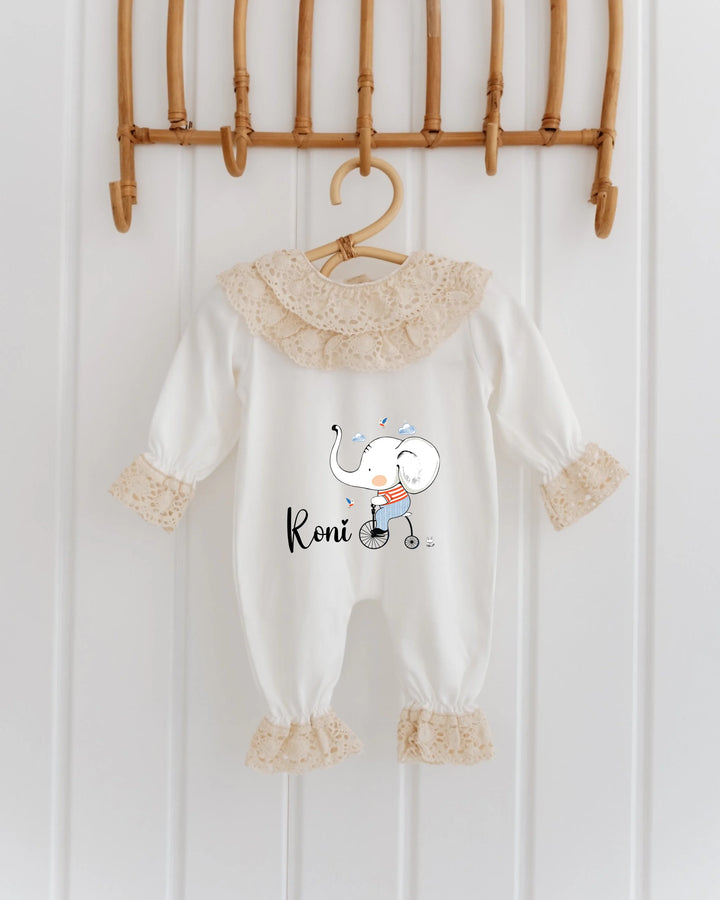 Olifant-geboortepakje met naam 'Roni', schattig olifantje op rolschaatsen, kanten details, perfect voor baby's.