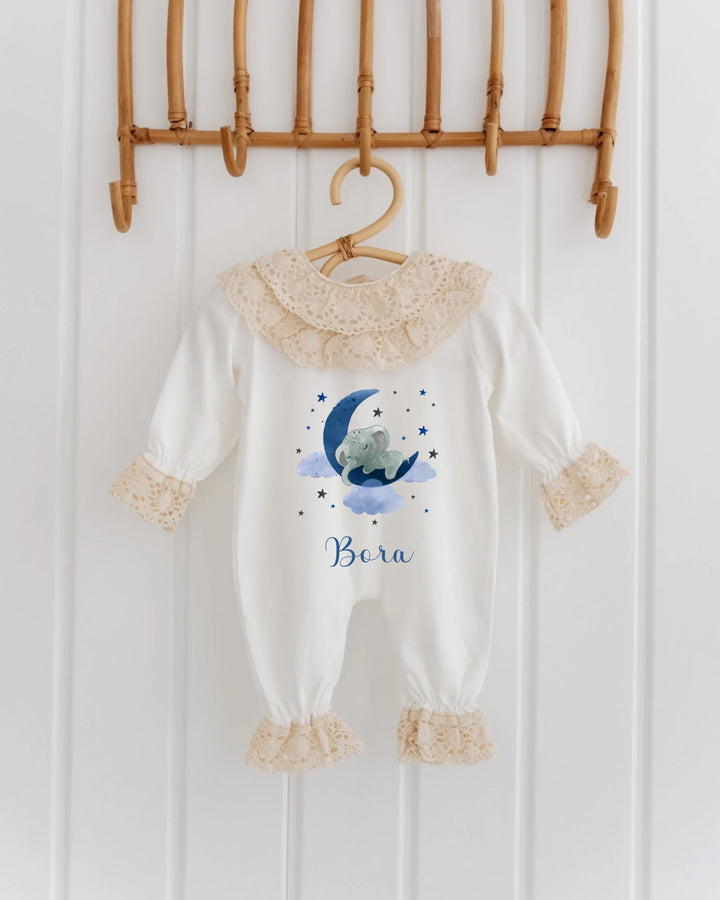 Gepersonaliseerd babypakje met blauwe olifant en maan, fijne kanten details, perfect als kraamcadeau.
