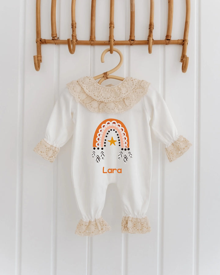 Kanten babypakje met regenboogdesign in terracotta en oranje, gepersonaliseerd met de naam Lara.