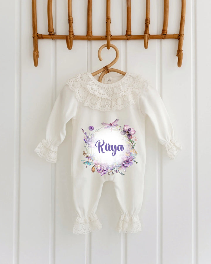 Gepersonaliseerd kanten babypakje met bloemen en de naam Riya, ideaal voor babyfotoshoots en kraamcadeaus.