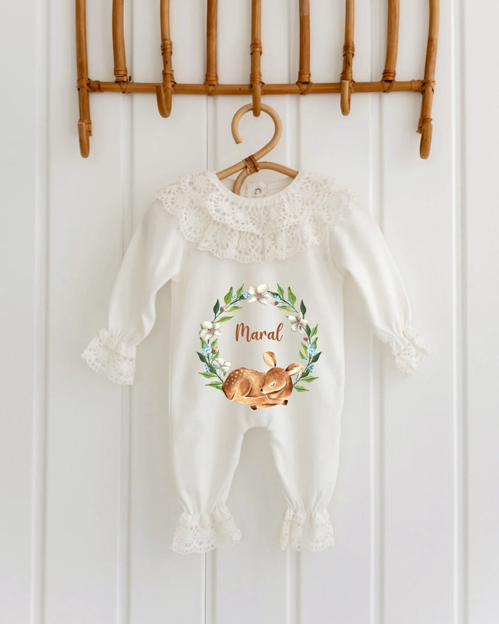 Elegant baby onesie with lace collar, featuring a hare in a floral wreath and personalized name 'Maral'.
