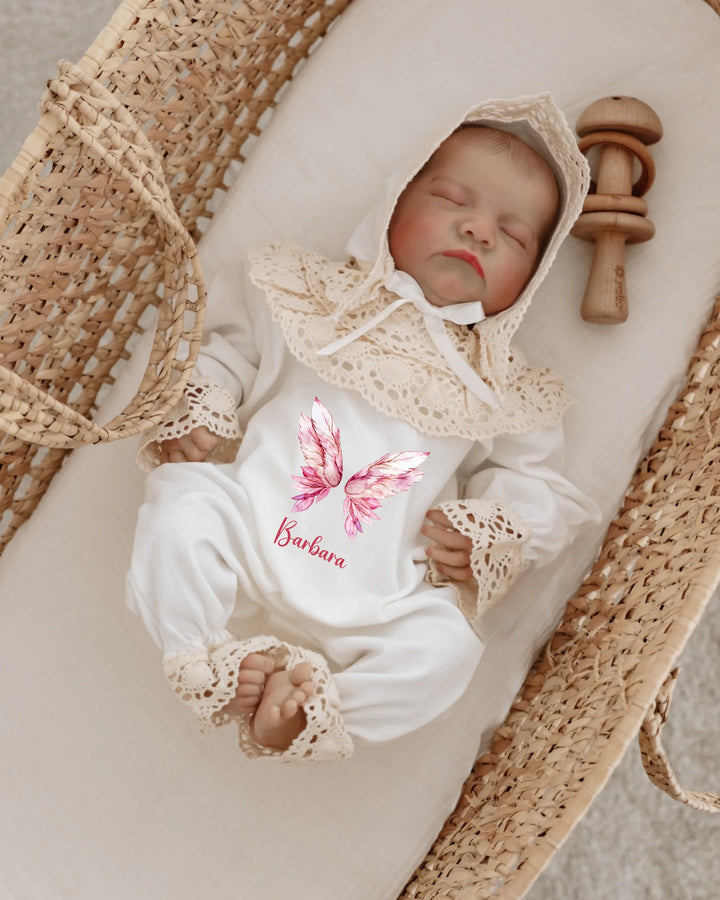 Gepersonaliseerd kanten babypakje met roze vleugels en naam voor meisjes, perfect als kraamcadeau.