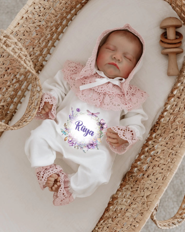 Slaap baby in een gepersonaliseerd kanten babypakje met naam, rustend in een mand met houten speelgoed.