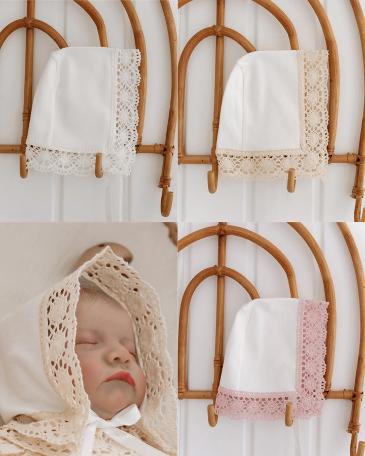 Schattige babyhoed met kant in wit, beige en roze, perfect voor newborn fotografie en stijlvolle outfits.