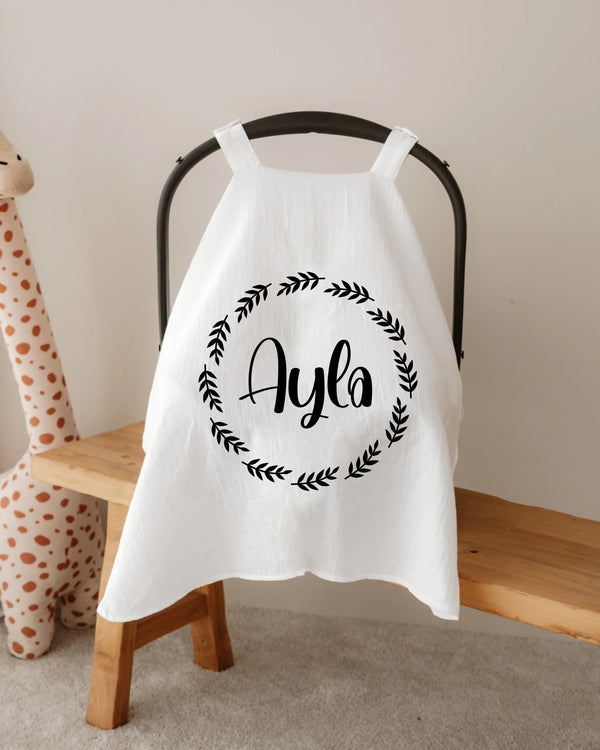 Gepersonaliseerde witte zonnekap met de naam 'Ayla' in een cirkel, modern ontwerp voor baby's.