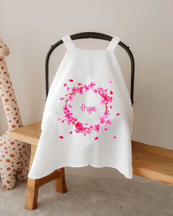 Gepersonaliseerde zonnekap met roze bloemenkrans voor autostoel, naam 'Arya' in het midden.