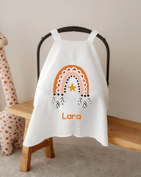 Gepersonaliseerde zonnekap voor autostoel met regenboog en naam Lara, stijlvol en functioneel voor babyaccessoires.