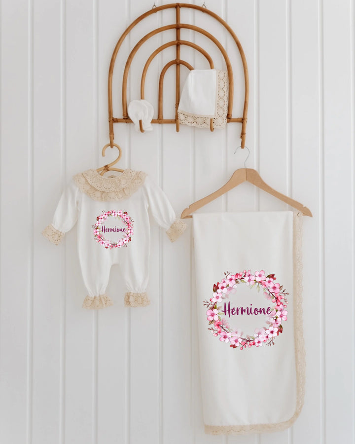 Elegante 4-delige newborn set voor meisjes met bloemenprint en gepersonaliseerde naam, ideaal als kraamcadeau.