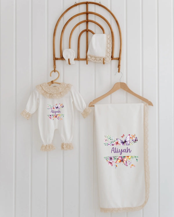Bloemen en vlinders babyset voor meisjes met romper, deken en accessoires in zachte pasteltinten.