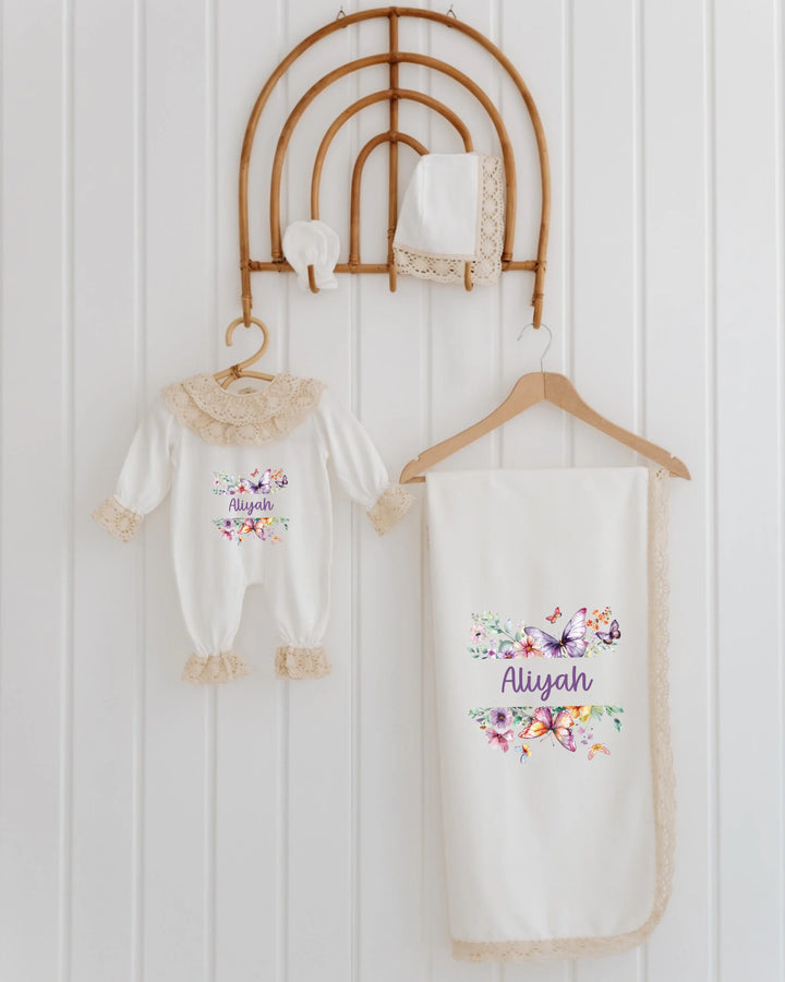 Bloemen en vlinders babyset voor meisjes met romper, deken en accessoires in zachte pasteltinten.