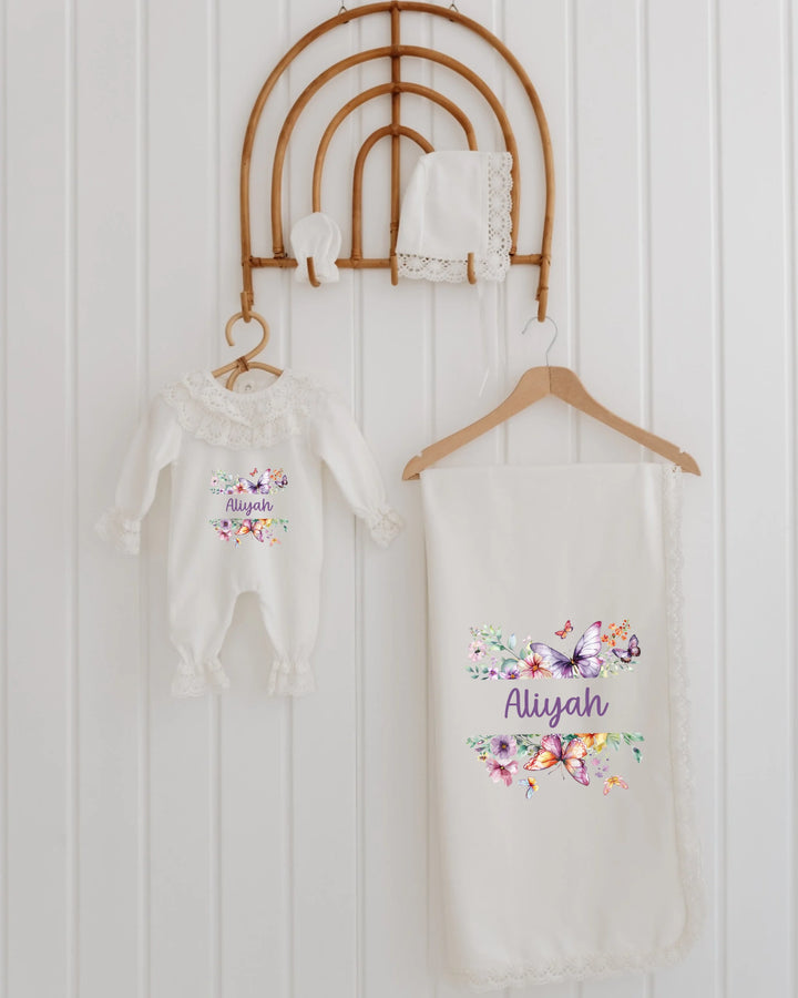 Bloemen en vlinders newborn kledingset met romper, deken en muts voor meisjes, zachte pasteltinten en romantische stijl.