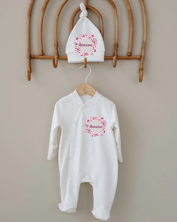 Gepersonaliseerd newborn boxpakje met naam en mutsje, bloemenkrans ontwerp, ideaal voor 0-3 maanden.