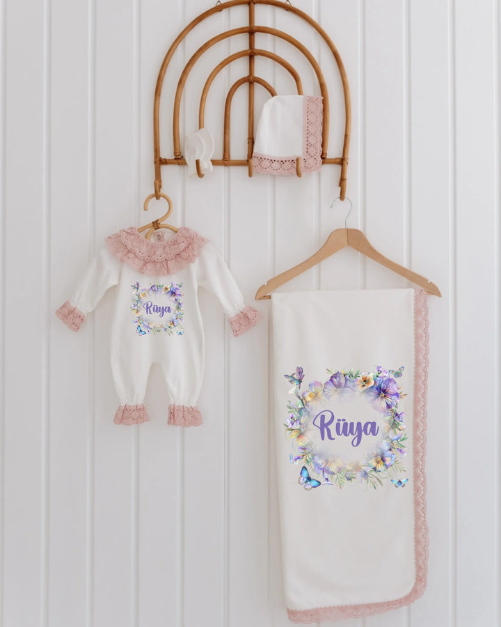 4-piece newborn girl set with floral print, personalized name 'Riya', featuring an outfit, blanket, and hat.