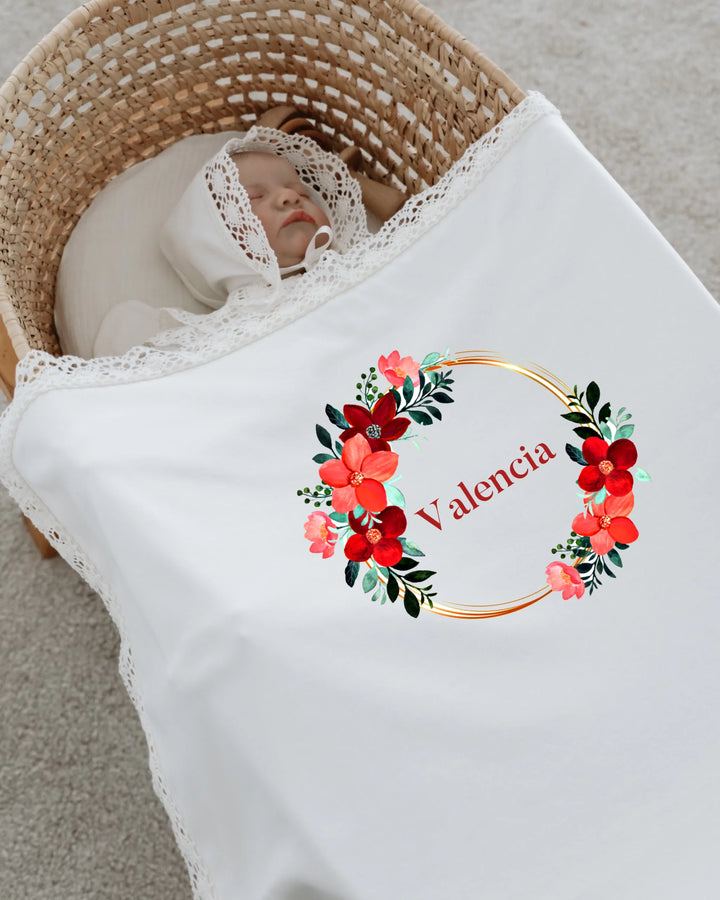 Newborn baby wrapped in floral blanket with personalized name Valencia, featuring romantic lace details.