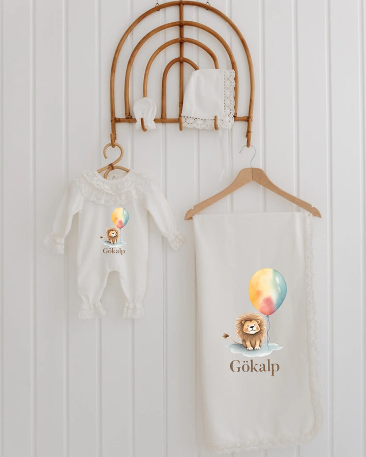 4-piece newborn set with lion and balloon design, personalized name, featuring romper, blanket, and hat with lace trim.