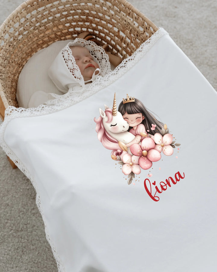 Baby girl sleeping in a cozy basket with unicorn and fairy design blanket personalized with the name 'Fiona'.