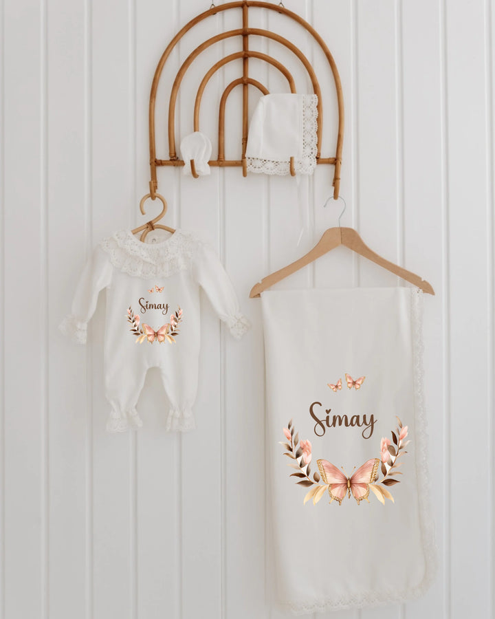 Gepersonaliseerde babyset met vlinderprint en bloemenkrans, inclusief rompertje en dekentje voor meisjes.