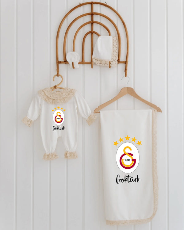 Galatasaray newborn set featuring romper, blanket, and accessories with logo and lace details for girls.