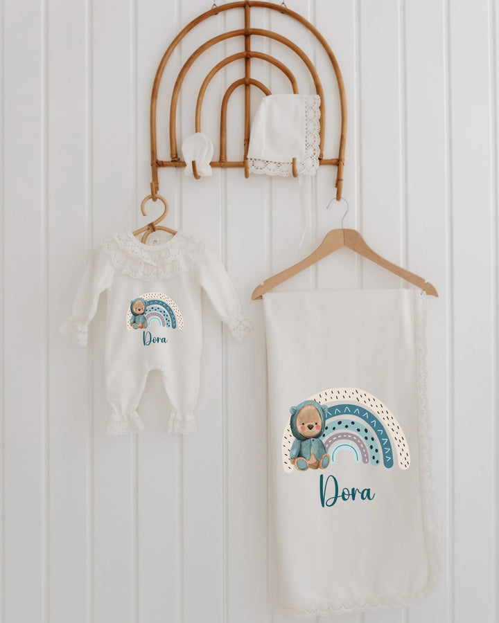 Kleurrijke regenboog babyset met rompertje, dekentje en muts, schattige teddybeer en personalisatie voor newborn meisjes.