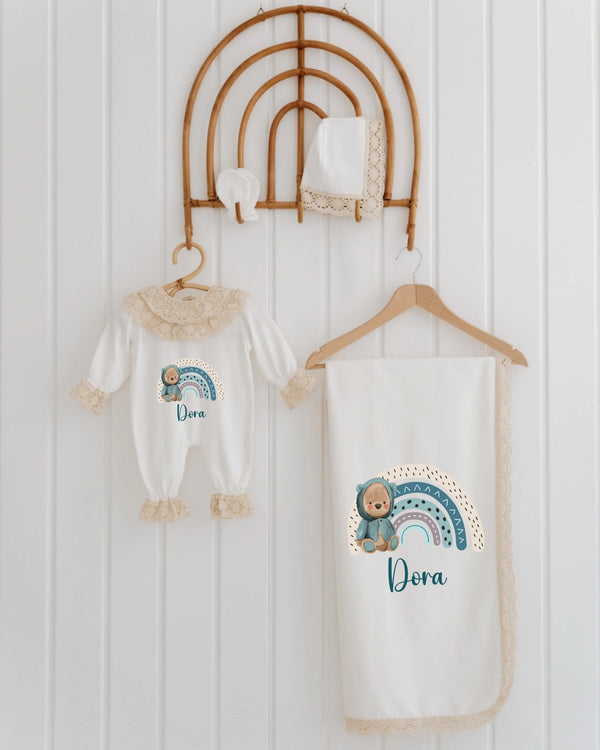 Luxe geboortepakje voor meisjes met regenboogprint en bijpassende dekentje, schattige teddybeer en naam "Dora".