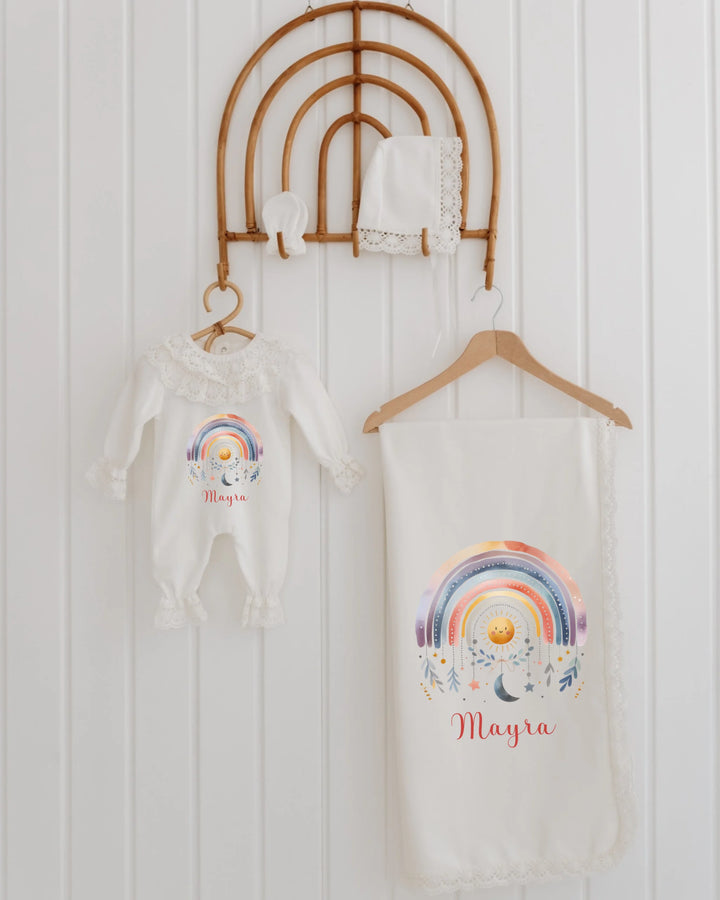 Newborn baby girl outfit set with personalized name, rainbow design, lace details, and matching accessories.