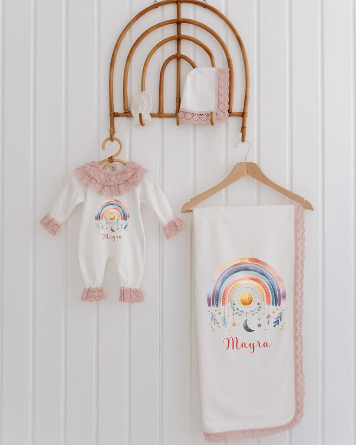 Kleurrijke regenboog newborn kledingset voor meisjes, inclusief romper, dekentje en mutsje met kantdetails.