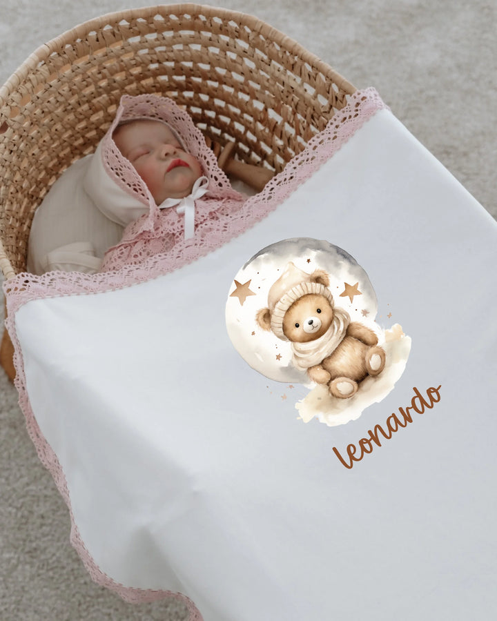Newborn baby wrapped in a soft blanket with a teddy bear design, personalized with the name Leonardo.