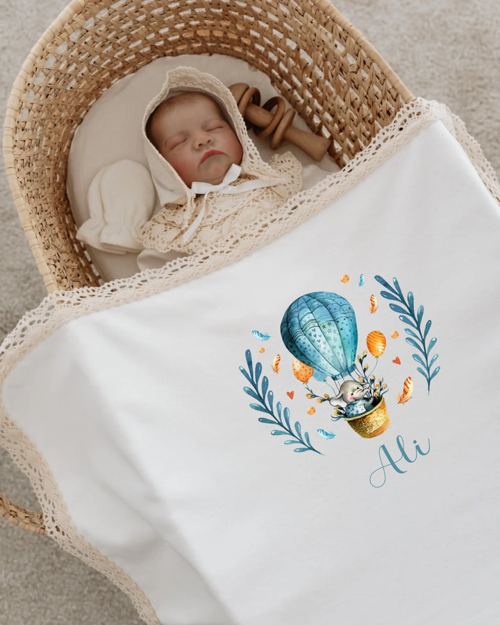 Slaapgende baby in mand met luchtballonprint deken en persoonlijke naam "Ali".