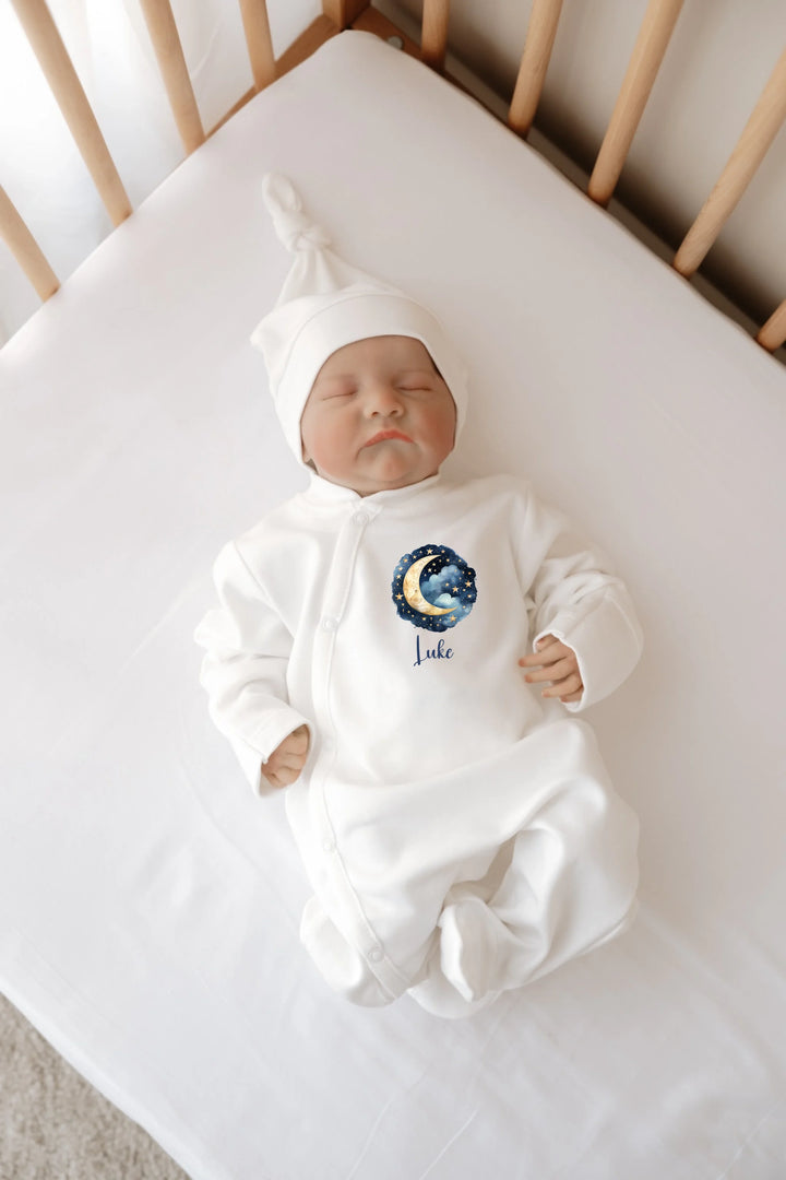 Wit baby boxpakje met maan-en-sterren ontwerp, perfect voor pasgeborenen, zacht katoen, met gepersonaliseerde naam.