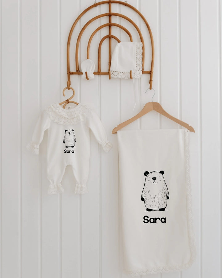 Minimalistische newborn set met berenillustratie en naam op rompertje en dekentje, stijlvol en uniek.