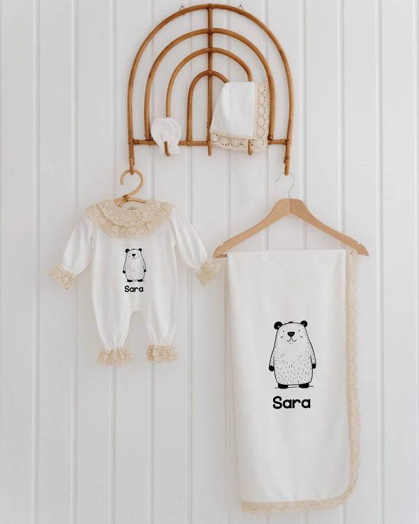 Minimalistische newborn kleding set met panda illustratie en naam 'Sara', inclusief romper en deken in Scandinavische stijl.