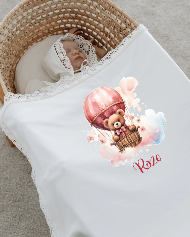 Roze teddybeer in luchtballon op een babydeken met kant, perfect voor een newborn setje voor meisjes.