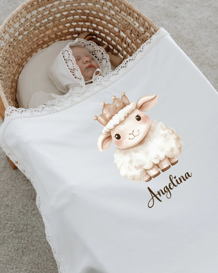 Newborn girl sleeping with a personalized blanket featuring a cute lamb illustration and the name Angelina.